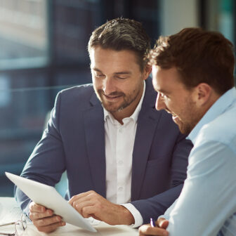 Deux hommes en costume lisant un document, symbolisant la préparation d'un audit