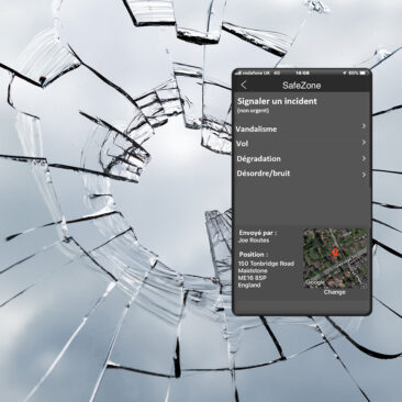 Vitre brisée avec un téléphone affichant l'application Safezone de Chubb Delta, permettant de signaler un incident